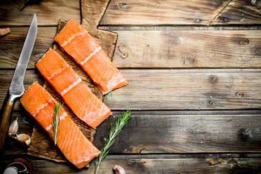 Çiğ somon balık biftek otlar ve sarımsak ile. Ahşap bir arka plan üzerinde