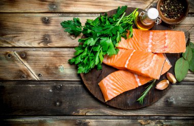 Çiğ somon fileto baharat ve taze maydanoz ile balık. Ahşap bir arka plan üzerinde.