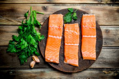 Çiğ somon fileto baharat ve taze maydanoz ile balık. Ahşap bir arka plan üzerinde.