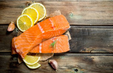 Çiğ somon biftek limon dilimleri ile. Ahşap bir arka plan üzerinde.