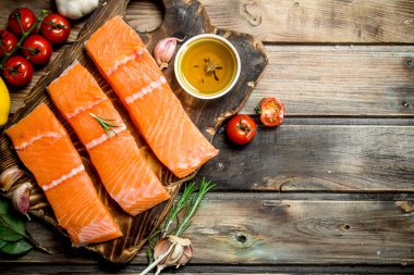 Çiğ somon fileto limon, domates ve otlar ile balık. Ahşap bir arka plan üzerinde.