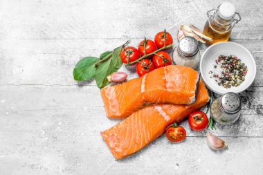 Çiğ somon biftek baharatlar, otlar ve zeytinyağı ile. Rustik bir arka plan üzerinde.