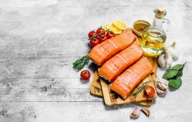 Çiğ somon fileto baharat, ot ve olgun domates ile balık. Rustik bir arka plan üzerinde.