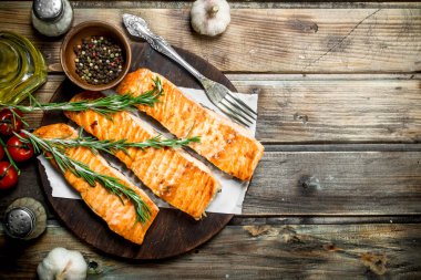 Baharat ve biberiye ile ızgara somon fileto. Ahşap bir arka plan üzerinde.