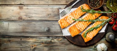 Baharat ve biberiye ile ızgara somon fileto. Ahşap bir arka plan üzerinde.