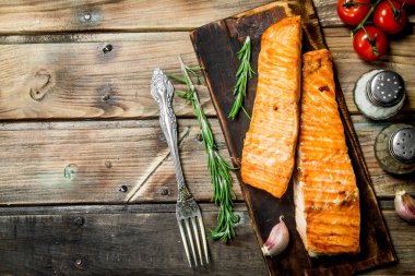 Baharat ve otlar ile ızgara somon fileto. Ahşap bir arka plan üzerinde.