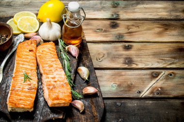 Biftek bir kesme Tahtası üzerinde limon ve baharat ile somon ızgara. Ahşap bir arka plan üzerinde.