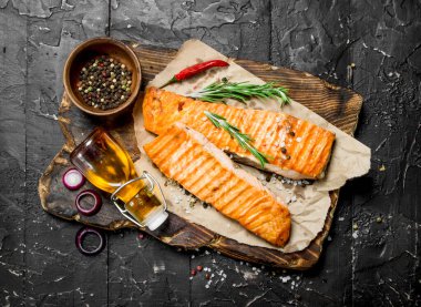 Baharat ve otlar ile ızgara somon fileto. Siyah bir rustik arka planda.