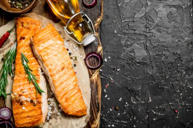 Baharat ve otlar ile ızgara somon fileto. Siyah bir rustik arka planda.