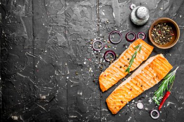 Baharat ve otlar ile ızgara somon fileto. Siyah bir rustik arka planda.