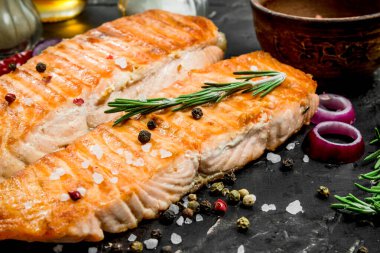 Baharat ve otlar ile ızgara somon fileto. Siyah bir rustik arka planda.