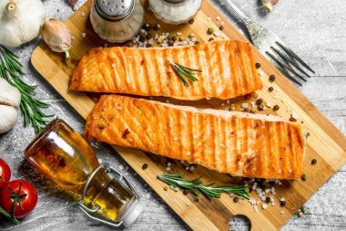 Baharat, ot ve domates ile ızgara somon fileto. Rustik bir arka plan üzerinde.