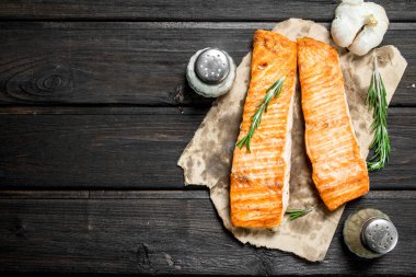Izgara somon fileto sarımsak, otlar ve baharatlar ile. Ahşap bir arka plan üzerinde.