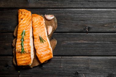 Izgara somon fileto sarımsak, otlar ve baharatlar ile. Ahşap bir arka plan üzerinde.