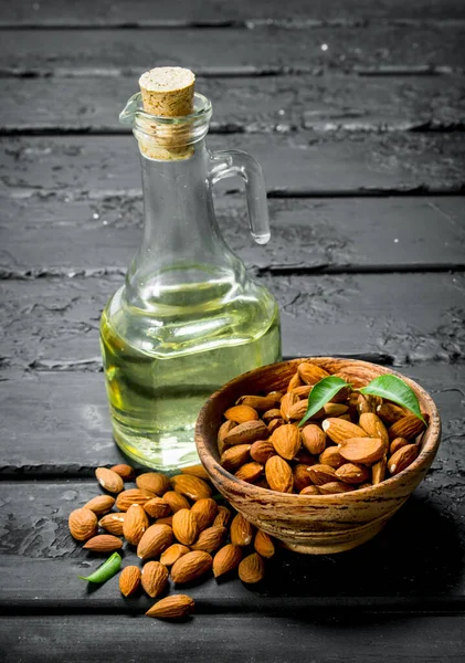 stock image Almond oil in a glass decanter. On black rustic background.