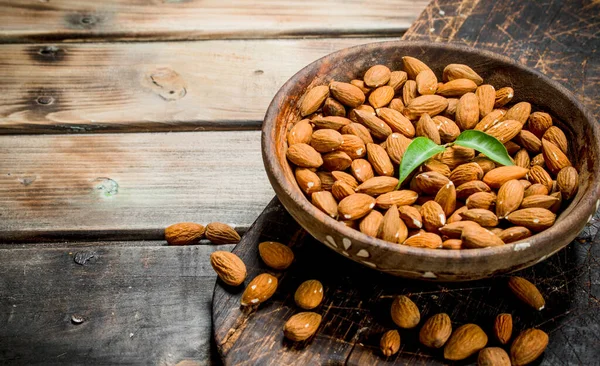 stock image Almonds in bowl . On a wooden background.