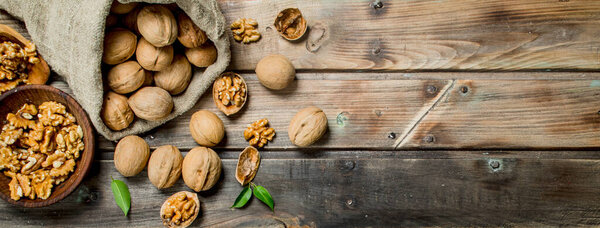 Walnuts in a bag . On a wooden background.