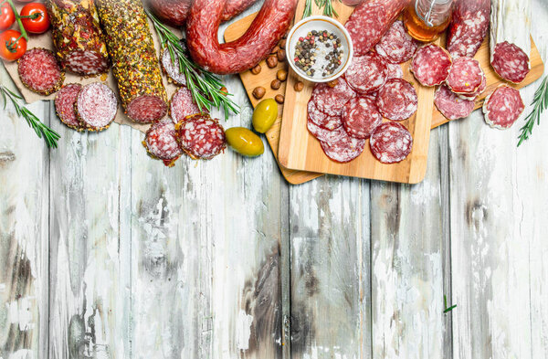 Assortment of different smoked salami. On a rustic background.