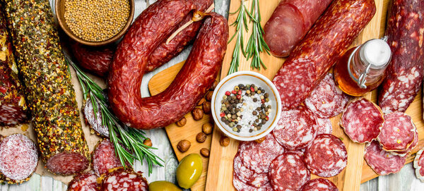 Assortment of different smoked salami. On a rustic background.