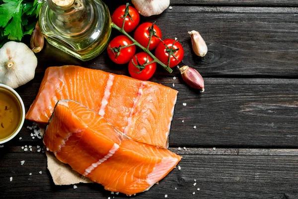 Sebze, baharat ve zeytinyağı ile çiğ somon balık fileto. Ahşap bir arka plan üzerinde.