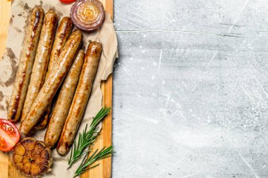 Baharat ve otlar yönetim kurulu ile sosis ızgara. Rustik bir arka plan üzerinde.