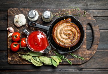 Kızarmış sosis sosu ve aromatik otlar ile. Ahşap bir arka plan üzerinde.