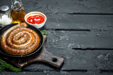 Domates soslu kızarmış sosis. Siyah rustik arka plan üzerinde.
