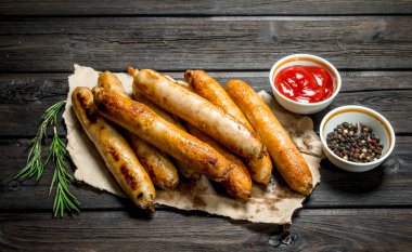 Güzel kokulu ızgara sosis domates soslu. Ahşap bir arka plan üzerinde.