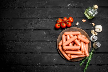 Baharat ile sosis haşlama. Rustik siyah arka plan üzerine.