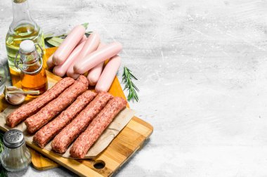 Baharat ve zeytinyağı ile çiğ Dana sosis. Rustik bir arka plan üzerinde.