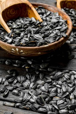 Ayçiçeği tohumu kepçe ile kase. Ahşap bir arka plan üzerinde.