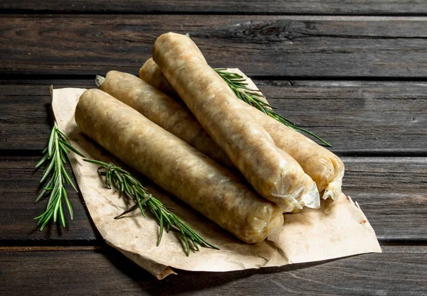 stock image Raw sausage with spices. On a wooden background.