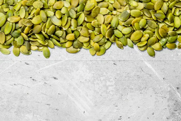 stock image Green pumpkin seeds. On a rustic background.