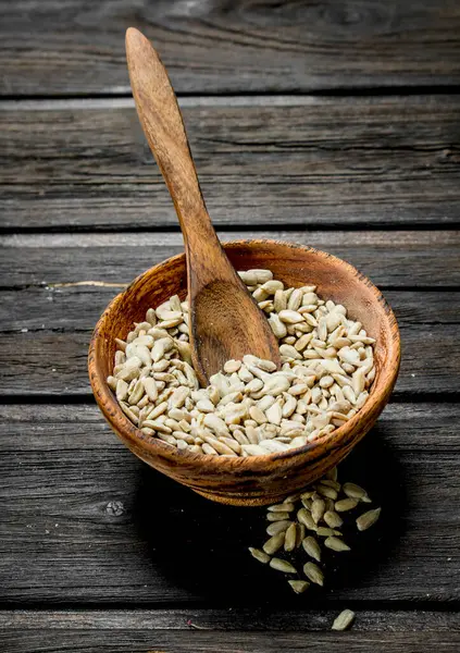 stock image Shelled sunflower seeds in a bowl. On a wooden background.