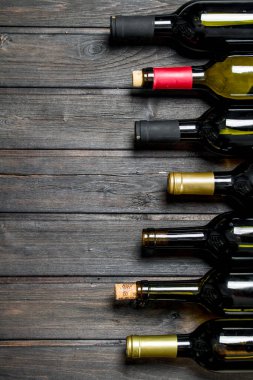 Beyaz ve kırmızı şarap şişe. Ahşap bir arka plan üzerinde.