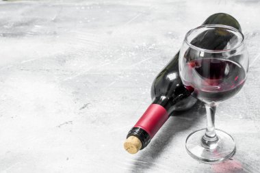 Şarap arka plan. Bir şişe kırmızı şarap bir bardak ile. Rustik bir arka plan üzerinde.