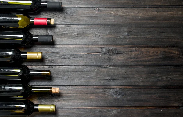 Beyaz ve kırmızı şarap şişe. Ahşap bir arka plan üzerinde.