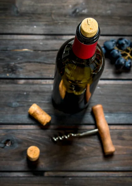 Flasche Rotwein Mit Trauben Auf Einem Hölzernen Hintergrund — Stockfoto