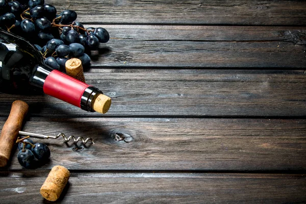 ぶどうと赤ワインのボトル 木製の背景に — ストック写真