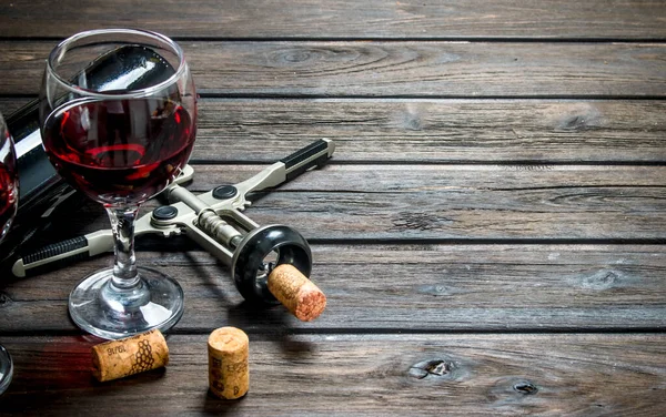 ワインの背景 コーク スクリューと赤ワイン 木製の背景に — ストック写真