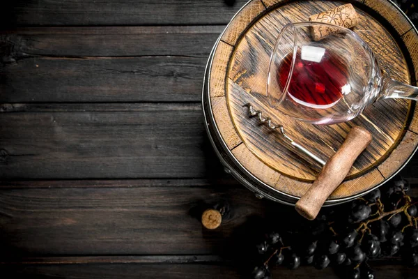 stock image Wine background. Barrel with red wine and grapes. On a wooden background.