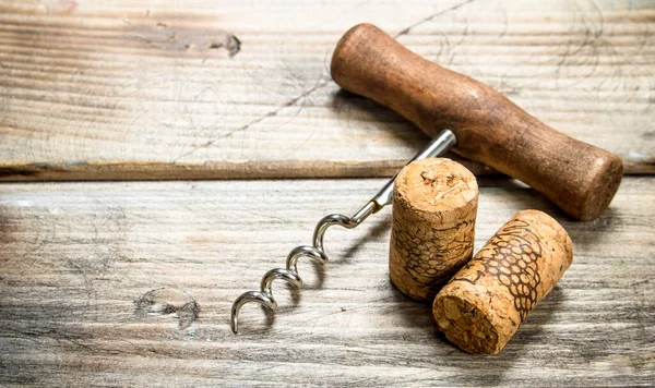 Stock image Corkscrew with corks. On a wooden background.