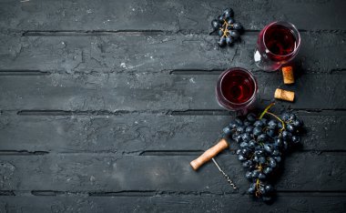 Şarap arka plan. Üzüm ve tirbuşon kırmızı şarap. Siyah bir rustik arka planda.