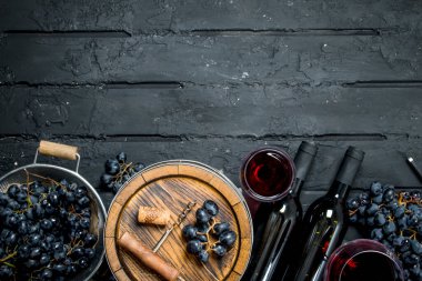 Şarap arka plan. Kırmızı şarap üzüm ve eski bir varil ile. Siyah bir rustik arka planda.