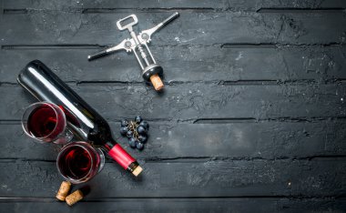 Tirbuşon kırmızı şarap. Siyah bir rustik arka planda.