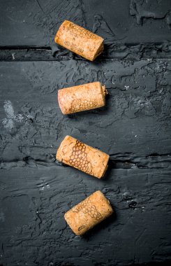 Şarap şişesi mantarlar. Siyah bir rustik arka planda.