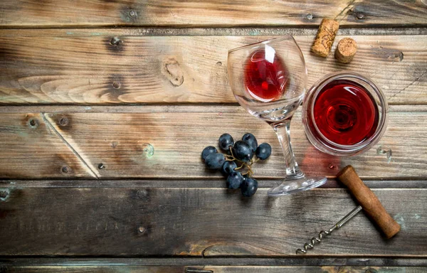 ブドウとらせん状のガラスで赤ワイン 木製の背景に — ストック写真