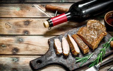 Kırmızı şarap ile sığır eti biftek kızartma. Ahşap bir arka plan üzerinde.