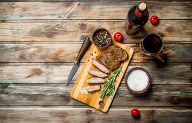 Kırmızı şarap ile sığır eti biftek kızartma. Ahşap bir arka plan üzerinde.