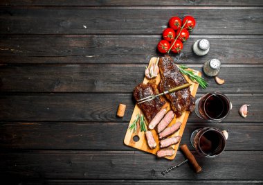 Kırmızı şarap ile ızgara sığır eti biftek. Ahşap bir masaya.